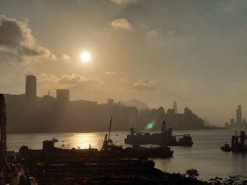 Scenic view of sea and buildings against sky during sunset