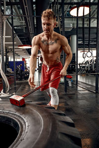 Portrait of young man exercising in gym