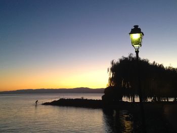 Scenic view of lake against clear sky during sunset