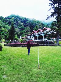 Rear view of man on field against building