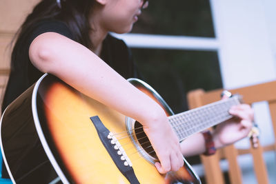 Midsection of person playing guitar