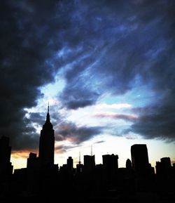 Low angle view of buildings against cloudy sky