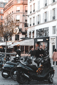 People on street against buildings in city