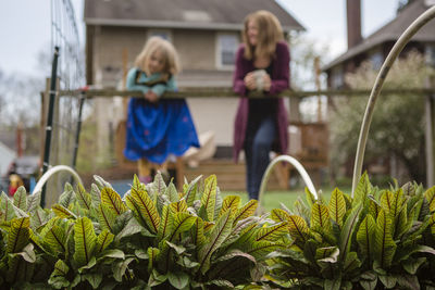 Close-up of girl and plants against building