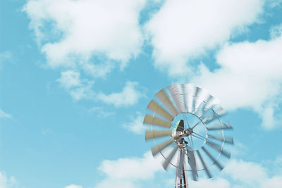 Low angle view of wind turbine against cloudy sky