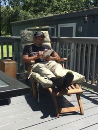 Full length of man reading book while sitting on seat