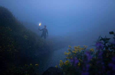 High angle view of man standing next to a pond 