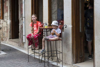 Siblings sitting at sidewalk cafe