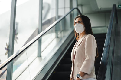 Woman standing on escalator