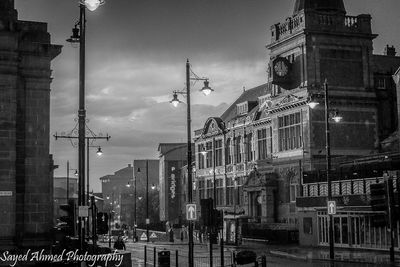 Buildings in city against cloudy sky