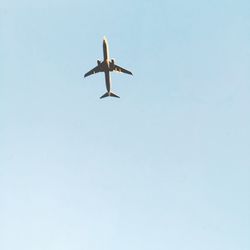 Low angle view of airplane flying against clear sky