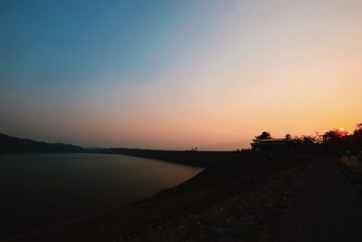Scenic view of lake against orange sky
