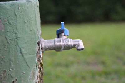 Close-up of old faucet on field