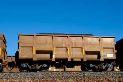 Train on railroad track against clear blue sky