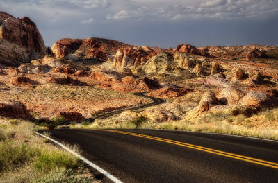 Road leading towards mountains against sky