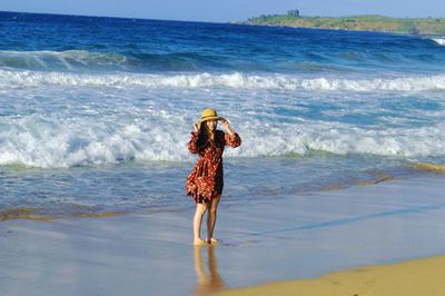 Full length of woman standing on beach