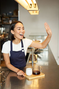 Portrait of young woman using mobile phone at table