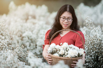 Portrait of woman with pink flowers against blurred background