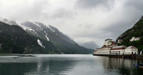 Scenic view of lake by mountains against sky