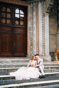 Couple sitting outside of building