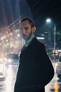 Man standing in illuminated city at night