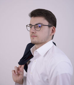 Close-up of young man standing against white background