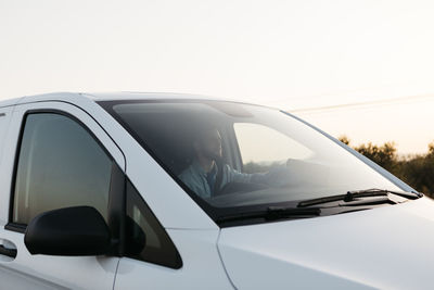 Delivery man in white van at sunset