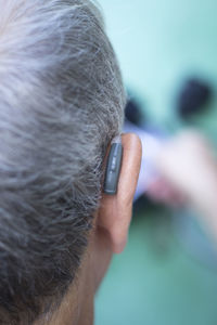 Rear view of man ear with hearing aid