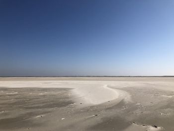 Scenic view of desert against clear blue sky