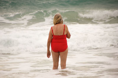 Rear view of woman standing on beach