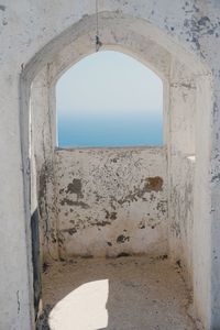 Arch on beach against clear sky