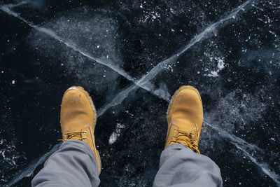 Low section of person standing on snow