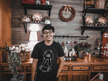 Portrait of smiling young man standing against wall