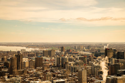 Aerial view of buildings in city against sky