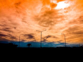 Silhouette windmills against sky during sunset