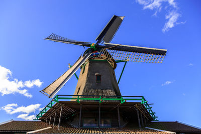 Low angle view of traditional windmill against blue sky