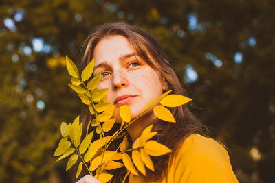 Portrait of young woman with yellow flowers