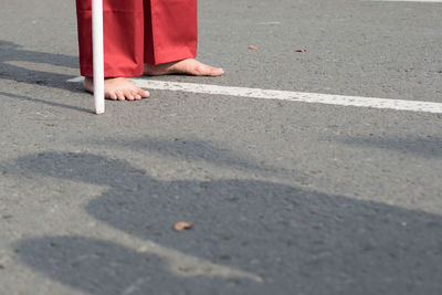 Low section of person walking on road