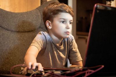 Boy looking away while sitting at home