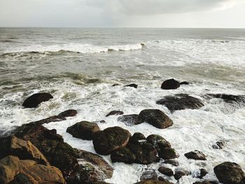 Scenic view of rocks in sea against sky