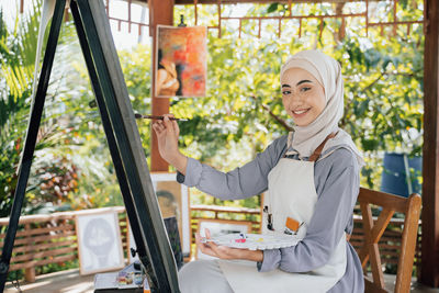 Portrait of young woman sitting on chair