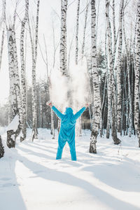 Full length of woman with arms outstretched in snow