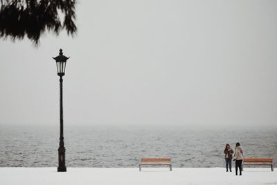 People on beach against clear sky