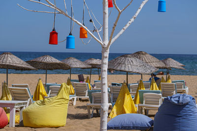 Chairs and parasols on beach against clear sky