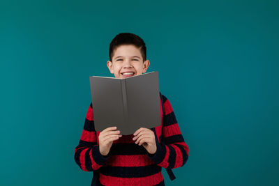 Young woman using digital tablet against blue background