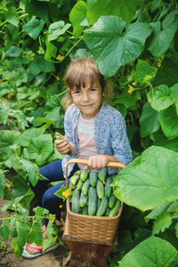 Portrait of young woman picking vegetables