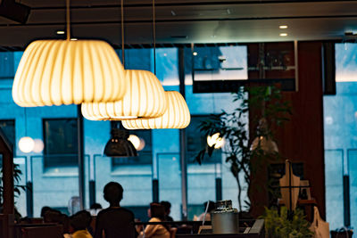 Illuminated pendant lights hanging in restaurant