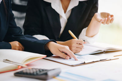Cropped image of businesswomen doing paperwork in office