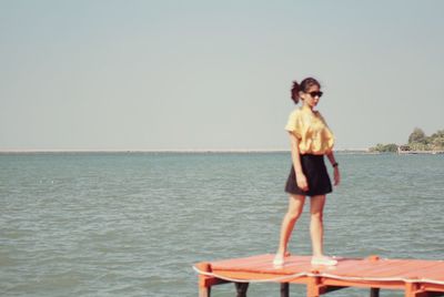 Full length of man standing at beach against clear sky