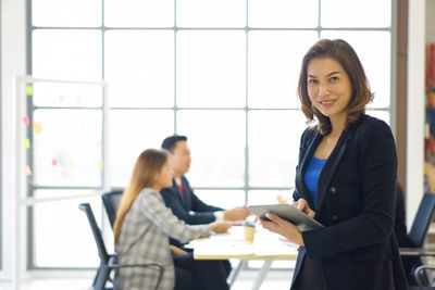 Portrait of a smiling young woman using phone